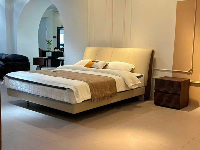 Giường ngủ bọc da nhập khẩu GIC191-18 được chụp từ góc chếch, nổi bật với đầu giường cao bọc da màu kem nhạt, có các đường…