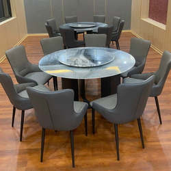 Bộ bàn ăn tròn hiện đại BA928-135 chụp chính diện, với mặt bàn đá vân xám đen có mâm xoay. Chân bàn trụ màu đen. Xung quan…