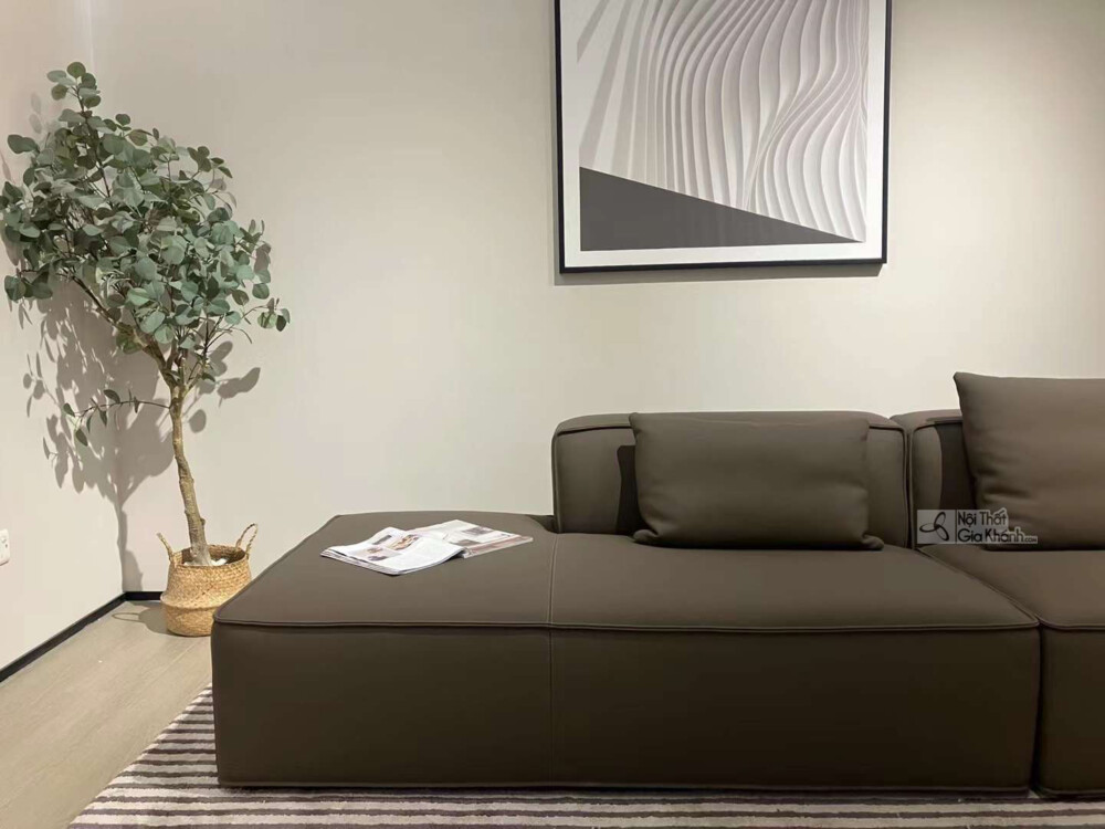 Chi tiết phần ghế dài và tựa lưng của bộ sofa SF1801B màu nâu đậm, với một cuốn tạp chí đặt trên đệm. Góc chụp cận cảnh ch…