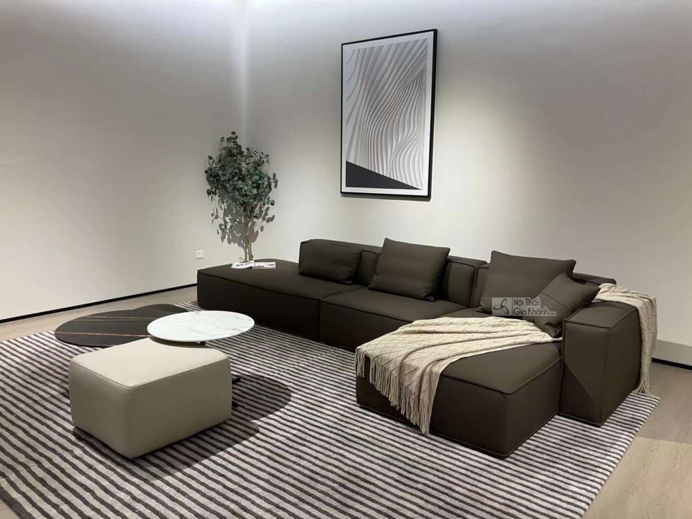 Toàn cảnh bộ sofa góc trái SF1801B màu nâu đậm trong một phòng khách hiện đại, được trang trí thêm cây xanh và tranh treo…