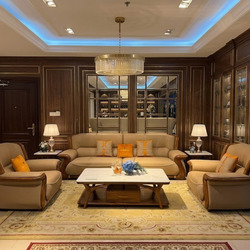 Bộ sofa hiện đại gồm một băng dài và hai ghế đơn bọc da bò màu nâu be, với khung gỗ Mun tự nhiên lộ ra ở tay vịn. Bàn trà…