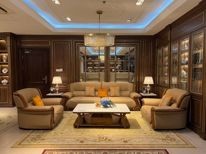 Bộ sofa hiện đại gồm một băng dài và hai ghế đơn bọc da bò màu nâu be, với khung gỗ Mun tự nhiên lộ ra ở tay vịn. Bàn trà…