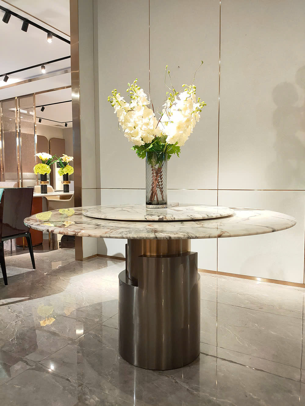 Bàn ăn BAQT226-135 được trưng bày trong không gian showroom của Gia Khánh, chụp từ góc thấp hơn để thể hiện sự bề thế của…