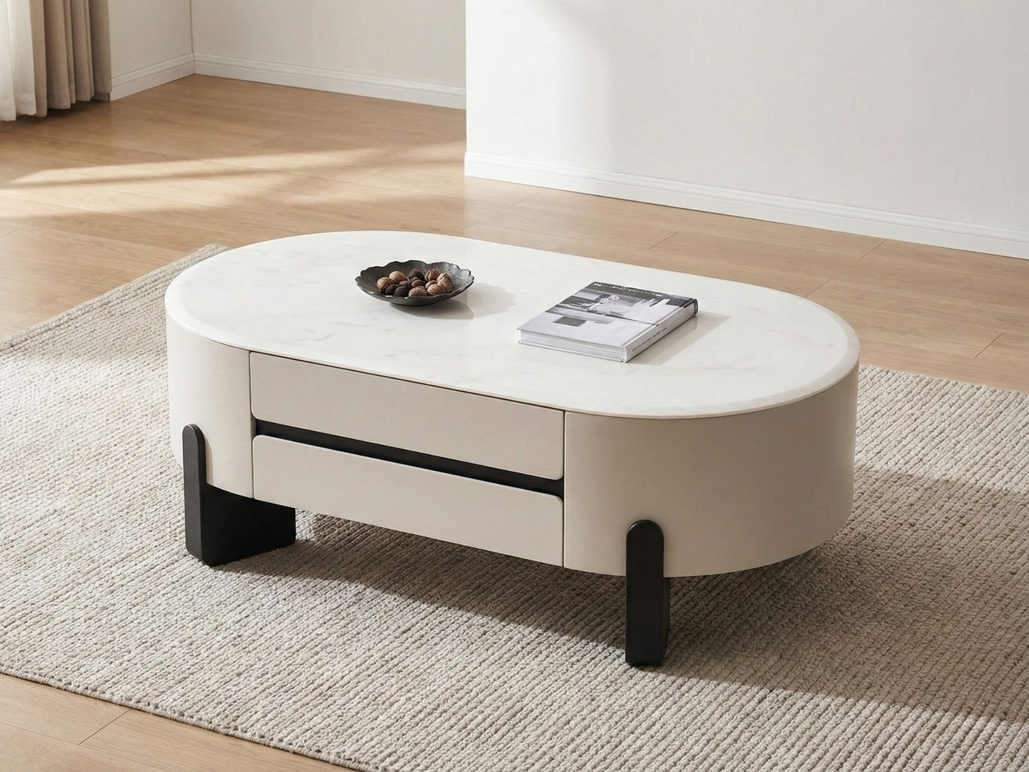 Bàn trà hình oval nhìn từ góc trên xuống, mặt đá tự nhiên vân trắng, thân bàn màu kem nhạt với hai ngăn kéo ẩn có tay nắm…