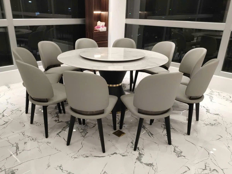 Bộ bàn ăn tròn 10 ghế BA805-Y925 được chụp từ góc hơi cao, tập trung vào bàn ăn mặt đá siêu pha lê màu trắng vân mây với m…