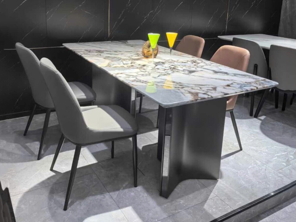 Bàn ăn mặt đá tự nhiên BAQ55-24 và ghế ăn hiện đại, chụp từ góc hơi chéo. Mặt bàn hình chữ nhật bo góc với vân đá trắng xá…