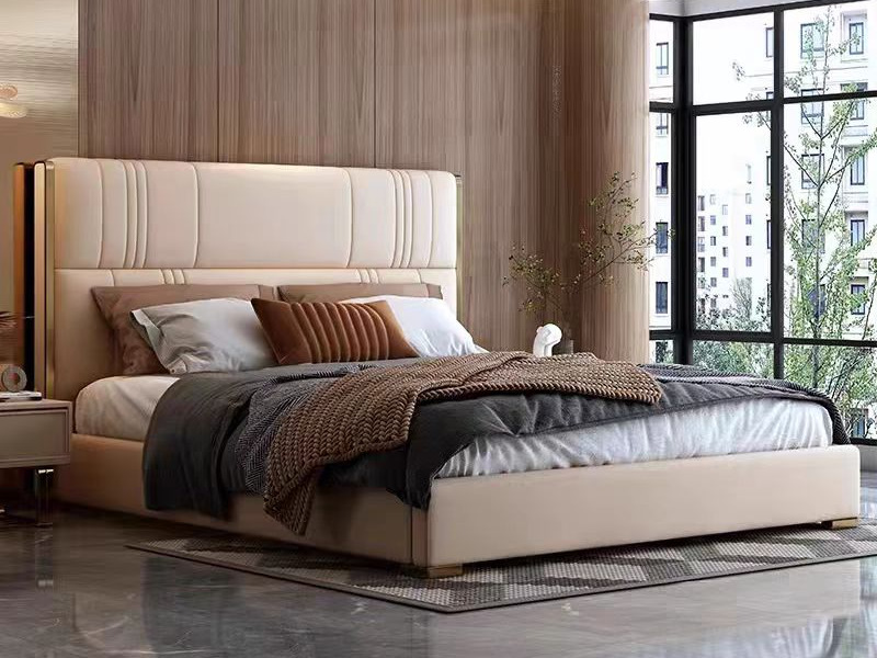 Giường ngủ bọc da cao cấp GI5365-18 được chụp ở góc chính diện hơi chếch, nổi bật phần đầu giường cao, bọc da màu kem với…