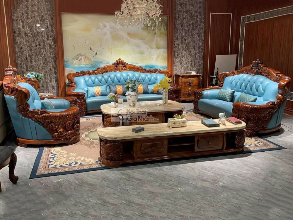 Bộ sofa tân cổ điển với khung gỗ mun chạm khắc tinh xảo, bọc da màu xanh ngọc nổi bật, đặt trong không gian phòng khách sa…