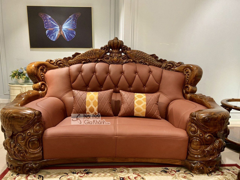 Ghế sofa băng đôi chụp chính diện, nổi bật với khung gỗ mun Nam Phi màu nâu đỏ được chạm trổ tinh xảo. Đệm ngồi và tựa lưn…