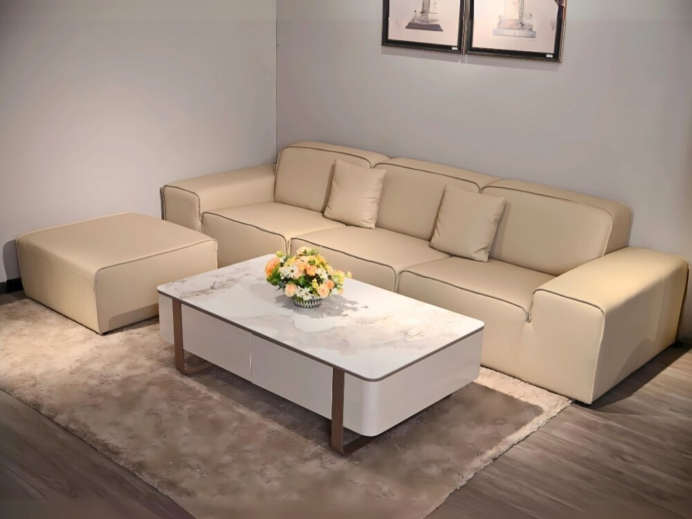Sofa băng SFA38-32 màu kem nhạt bọc da bò, kết hợp đôn và bàn trà mặt đá marble trắng, chân kim loại, đặt trên thảm lông t…