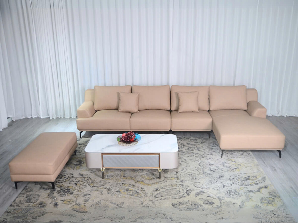 Bộ sofa da AURELIA 3 băng góc trái màu be nhạt, kèm theo một đôn rời, chụp từ phía trước. Sofa đặt trong không gian phòng…