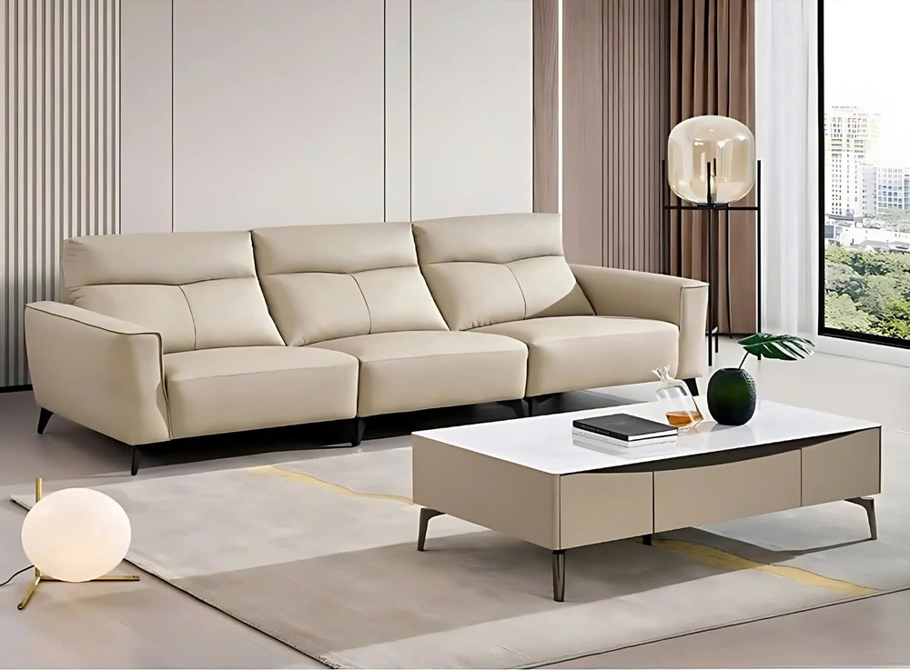 Sofa băng SF8137 màu kem nhạt, bọc da bò thật, được chụp ở góc ngang trong không gian phòng khách hiện đại. Sofa có ba chỗ…