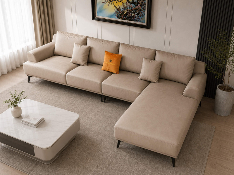 Sofa da AURELIA 3 băng góc trái màu be nhạt, chụp từ góc cao bên trái, nhấn mạnh phần góc chữ L và sự kết hợp với bàn trà…
