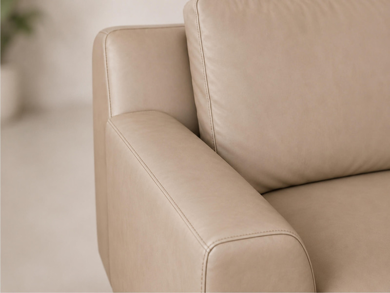 Cận cảnh phần tay vịn và đệm tựa lưng của sofa da AURELIA màu be nhạt. Chất liệu da Lex nhân tạo cao cấp với bề mặt mịn mà…