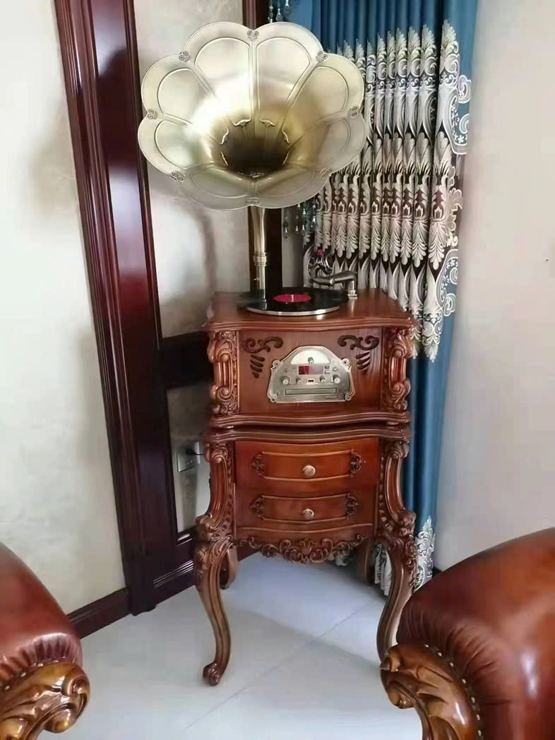 Hình ảnh cận cảnh máy phát nhạc GK01, tập trung vào phần thân máy và loa kèn. Thân máy gỗ sồi tự nhiên màu nâu đỏ với các…