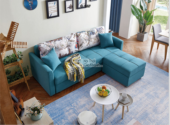 Ghế sofa giường lệch góc đa năng SF119B-31 màu xanh ngọc bọc vải, được chụp từ trên cao trong một phòng khách hiện đại. So…