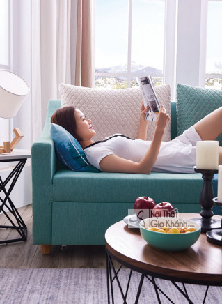 Cận cảnh một người phụ nữ đang nằm thư giãn trên phần góc của bộ sofa đa năng SF258-1F màu xanh ngọc bích. Góc chụp ngang…