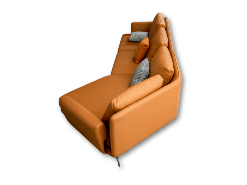Góc chụp từ trên cao xuống phần góc phải của bộ sofa da màu cam, trên nền trắng. Hình ảnh tập trung vào đường cong mềm mại…