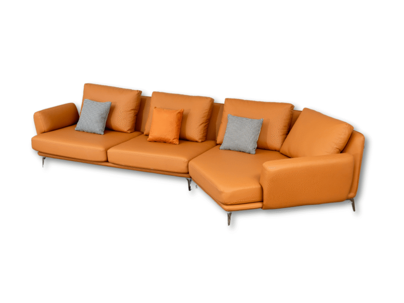 Toàn cảnh bộ sofa da góc màu cam chụp từ góc cao, trên nền trắng tinh khiết, làm nổi bật hình dáng chữ L tinh xảo. Các gối…