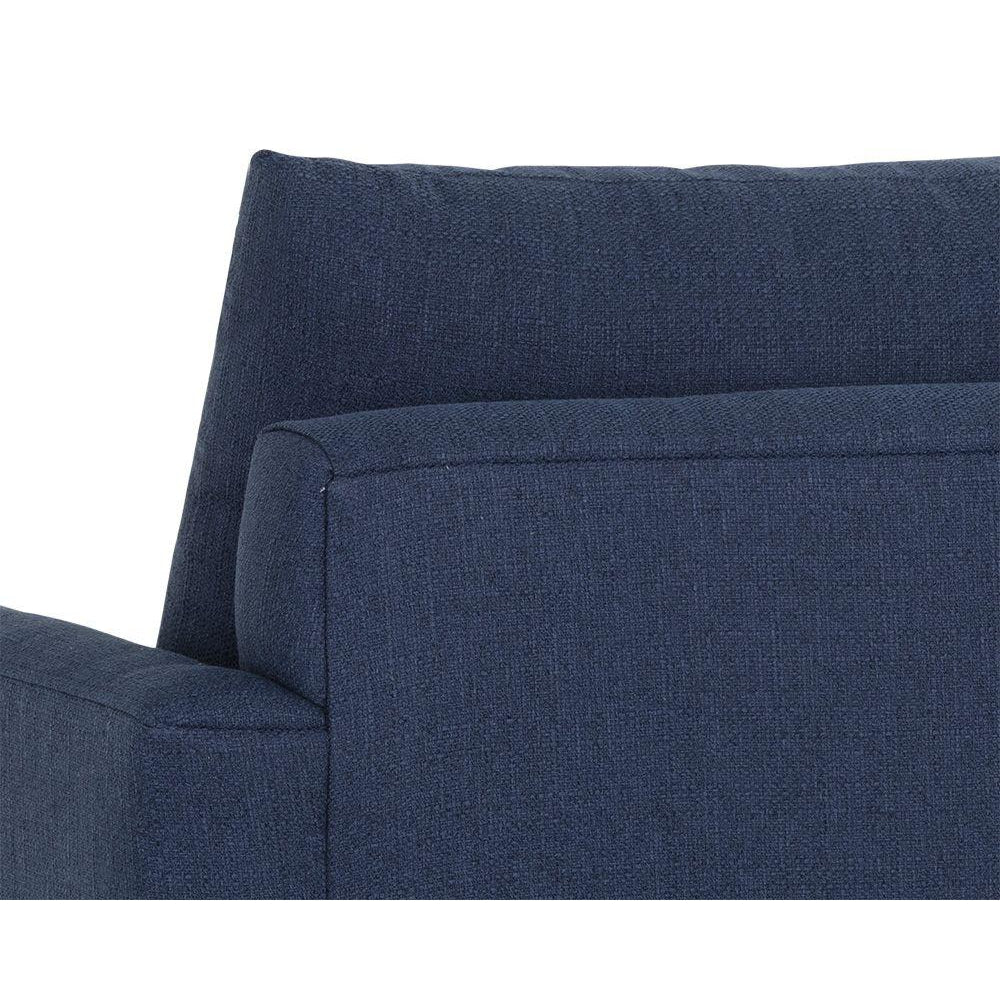 Cận cảnh chi tiết phần tay vịn và đệm tựa lưng của sofa băng bọc vải màu xanh đậm. Hình ảnh cho thấy rõ kết cấu vải dệt ca…