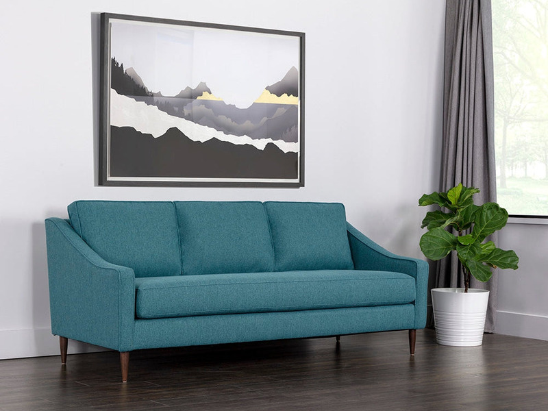 Sofa băng ba chỗ ngồi màu xanh ngọc bọc vải, đặt trong không gian phòng khách hiện đại. Góc chụp hơi chéo từ phía trước, c…