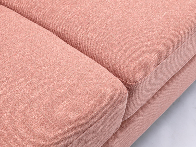 Ảnh cận cảnh chi tiết bề mặt vải bọc sofa màu hồng nhạt, cho thấy rõ kết cấu dệt của sợi vải và đường may chắc chắn giữa c…