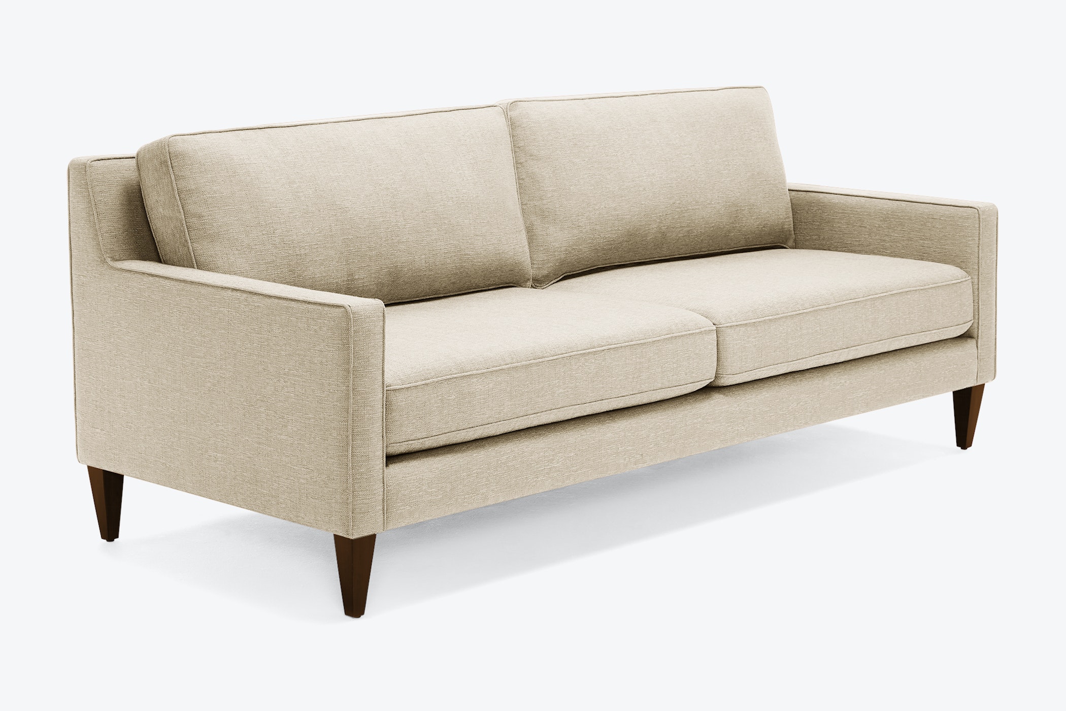 Sofa băng bọc vải màu be nhạt, chụp nghiêng từ phía trước bên phải, nổi bật trên nền trắng. Sofa có thiết kế hiện đại với…