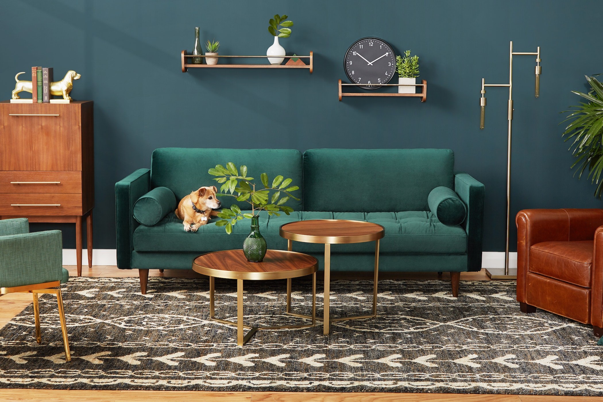 Sofa băng 3 chỗ bọc vải màu xanh lá cây đậm, đặt trong phòng khách phong cách Mid-Century với tường xanh đậm, sàn gỗ và th…
