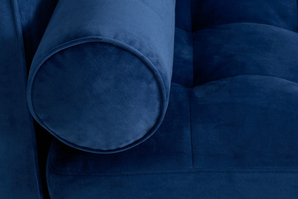 Cận cảnh góc tựa lưng và gối ôm tròn của sofa bọc vải màu xanh navy. Chi tiết đường may tinh tế trên vải mềm mại, tạo cảm…