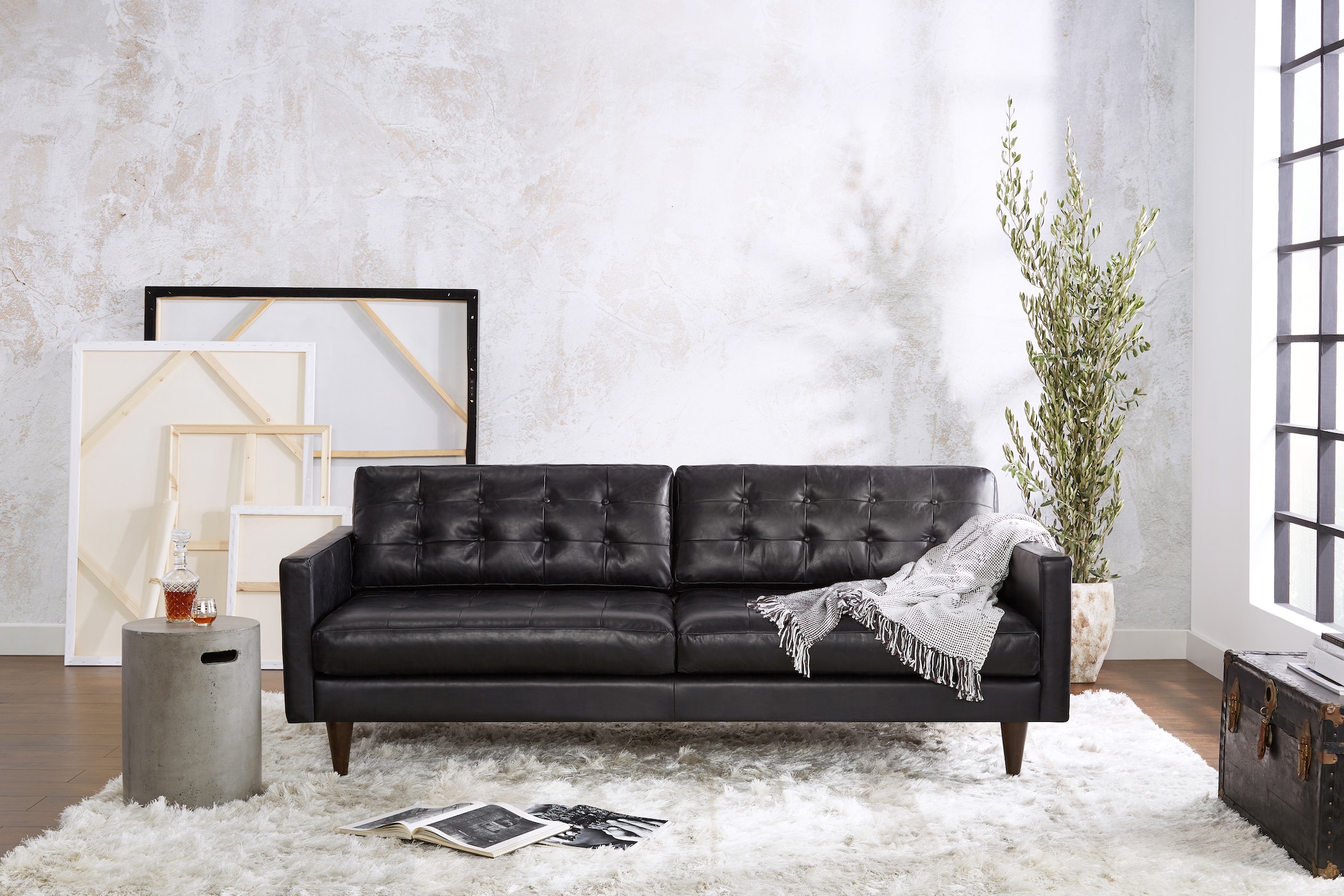 Sofa băng bọc da màu đen, phong cách hiện đại, đặt trong không gian phòng khách tối giản. Sofa có thiết kế thanh lịch với…