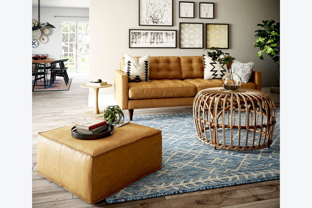 Sofa băng bọc da màu nâu caramel, đặt trong phòng khách ấm cúng với ánh sáng dịu nhẹ. Sofa có thiết kế hiện đại, kết hợp v…