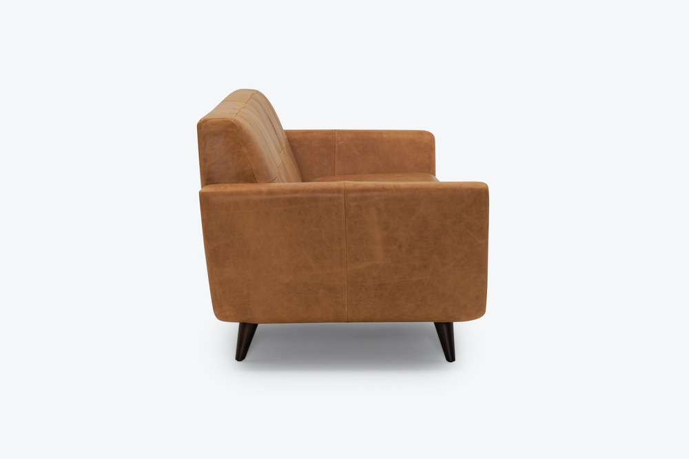 Sofa băng dáng thuyền Hughes SF-555 màu nâu da bò, chụp cận cảnh từ góc bên phải trên nền trắng. Hình ảnh tập trung vào ph…