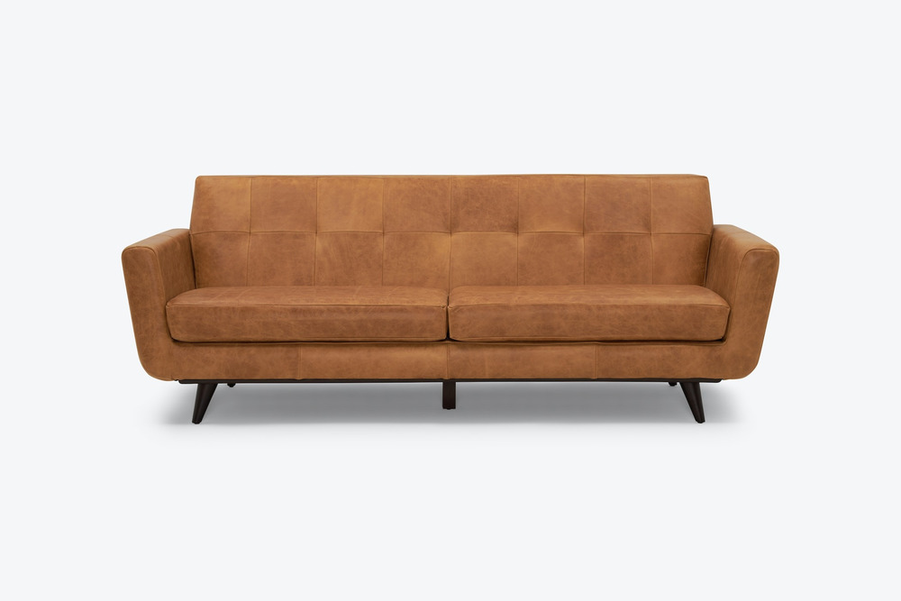 Sofa băng dáng thuyền Hughes SF-555 màu nâu da bò, chụp chính diện từ phía trước trên nền trắng. Ghế có thiết kế tối giản…