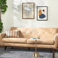 Sofa băng dáng thuyền Hughes SF-555 màu nâu vàng nhạt, đặt trong không gian phòng khách hiện đại với tường gạch trắng, cây…