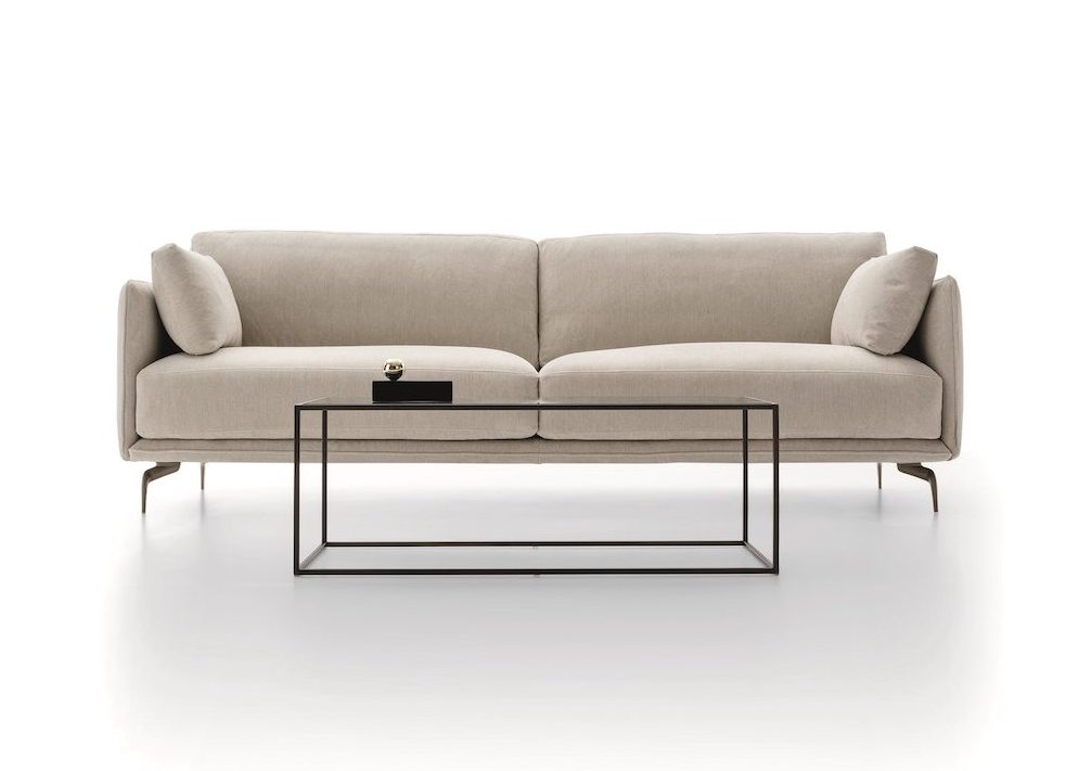 Sofa băng hai chỗ ngồi phong cách hiện đại, chụp chính diện trên nền trắng studio. Sofa bọc vải màu be nhạt, có tay vịn hơ…