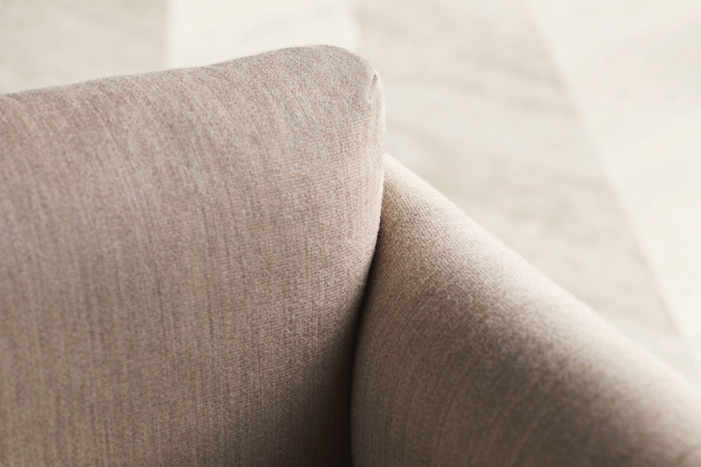 Hình ảnh cận cảnh chất liệu vải bọc sofa màu be nhạt, cho thấy rõ kết cấu sợi vải dệt kim mềm mại và bền chắc. Bề mặt vải…