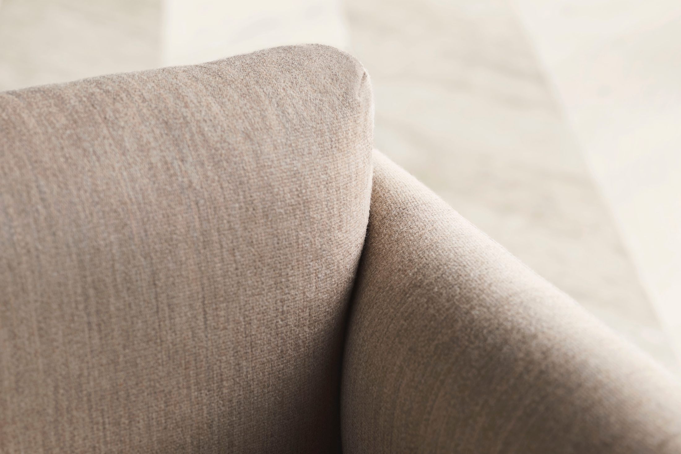 Hình ảnh cận cảnh chất liệu vải bọc sofa màu be nhạt, cho thấy rõ kết cấu sợi vải dệt kim mềm mại và bền chắc. Bề mặt vải…