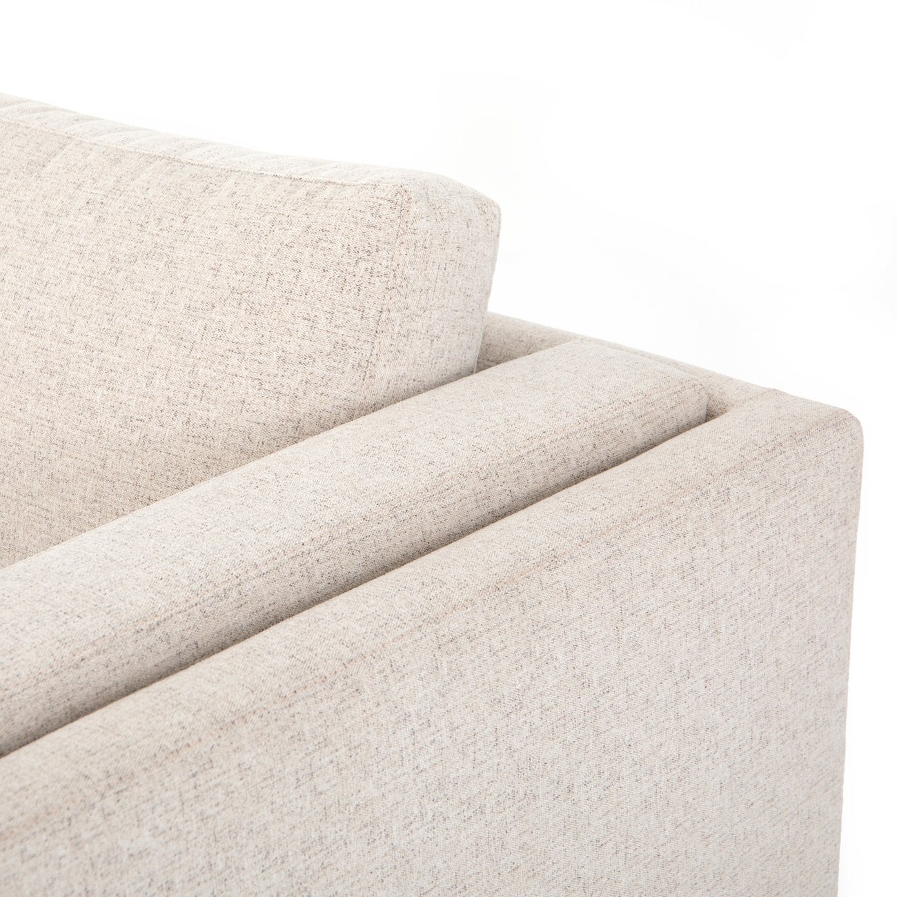 Cận cảnh chi tiết tay vịn và đệm tựa lưng của sofa Ezra SF-222. Bề mặt vải bọc màu be nhạt có kết cấu dệt rõ nét, mang lại…