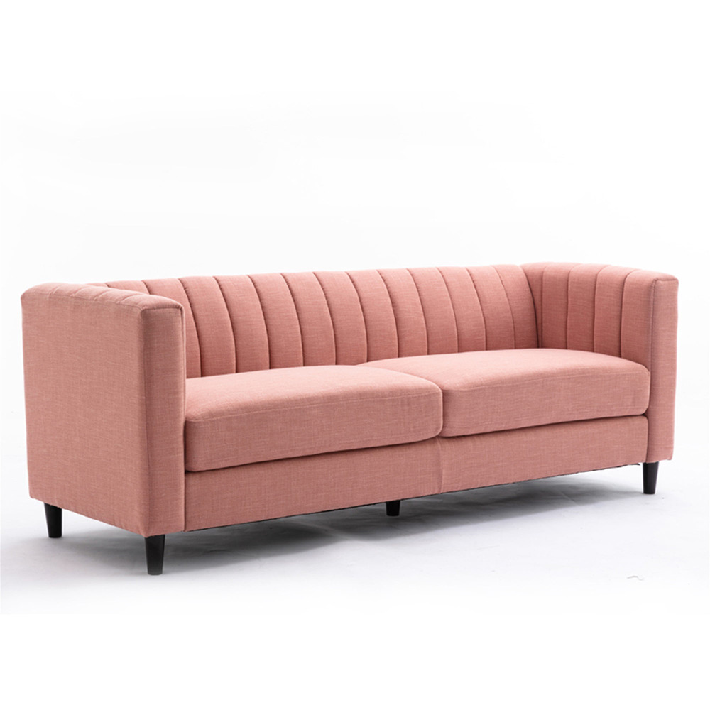 Sofa băng bọc vải màu hồng nhạt được chụp từ góc nghiêng trên nền trắng, cho thấy rõ chiều sâu và tổng thể thiết kế. Tựa l…