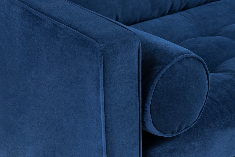 Cận cảnh góc tựa lưng và gối ôm tròn của sofa bọc vải màu xanh navy. Chi tiết đường may và chất liệu vải được thể hiện rõ…