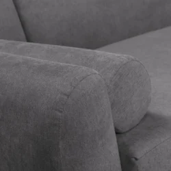 Cận cảnh chi tiết tay vịn và lưng tựa của một chiếc sofa bọc vải màu xám. Tay vịn được thiết kế bo tròn, liền mạch với lưn…