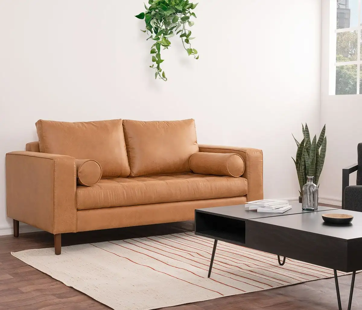 Sofa băng 3 chỗ màu nâu da bò, chụp từ góc thấp hơn, làm nổi bật chân ghế gỗ và sự kết hợp hài hòa với bàn trà đen và thảm…