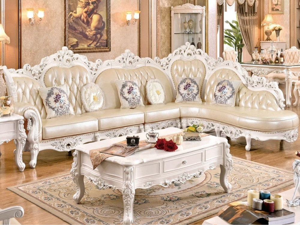 Sofa góc tân cổ điển SB905-3B màu kem sang trọng, được chụp trong bối cảnh phòng khách rộng rãi. Sofa có khung gỗ chạm khắ…