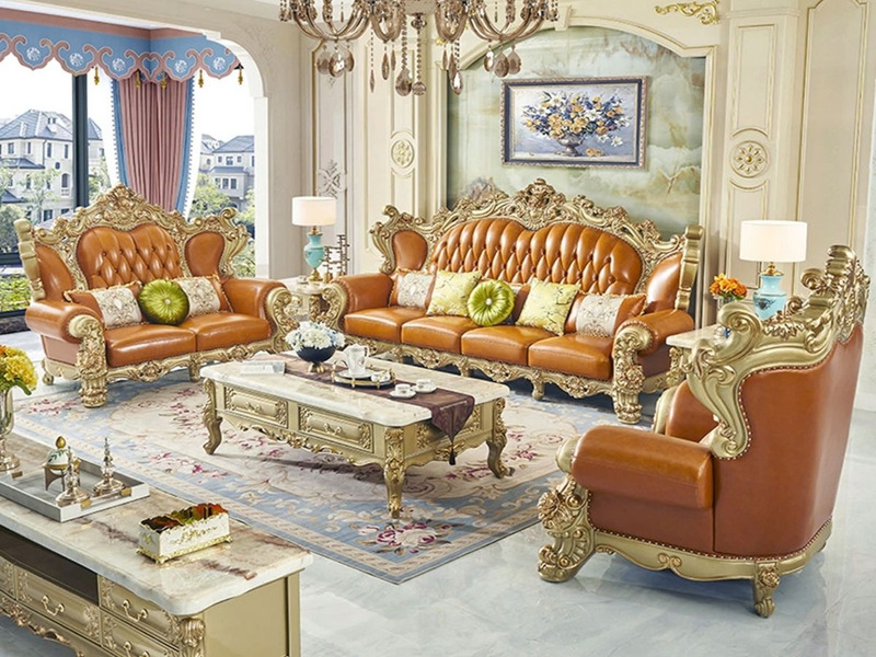 Bộ sofa tân cổ điển gồm ghế băng dài, đôi và đơn, chụp góc rộng trong phòng khách sang trọng. Ghế bọc da nâu caramel, khun…