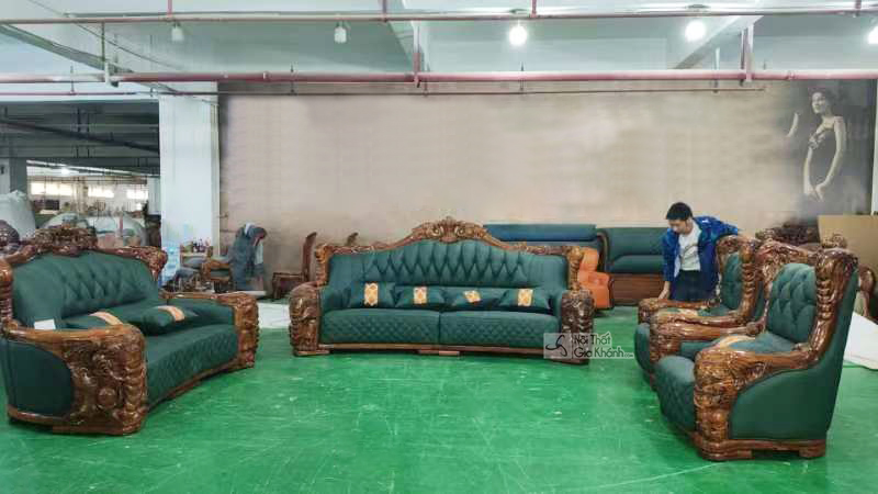 Toàn cảnh bộ sofa gỗ mun GK07-1124 với lớp bọc da màu xanh lá đậm, được chụp trong xưởng sản xuất. Các chi tiết khung gỗ m…