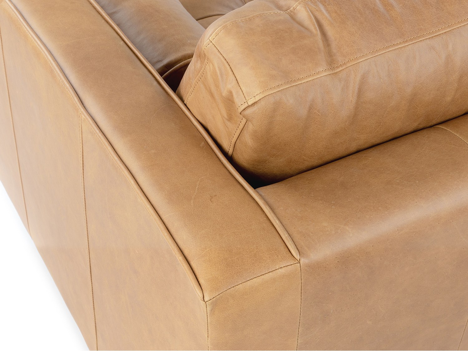 Cận cảnh chi tiết góc tay vịn của ghế sofa Charme 001, cho thấy đường chỉ may tinh tế, ẩn dưới lớp da màu nâu vàng. Gối tr…