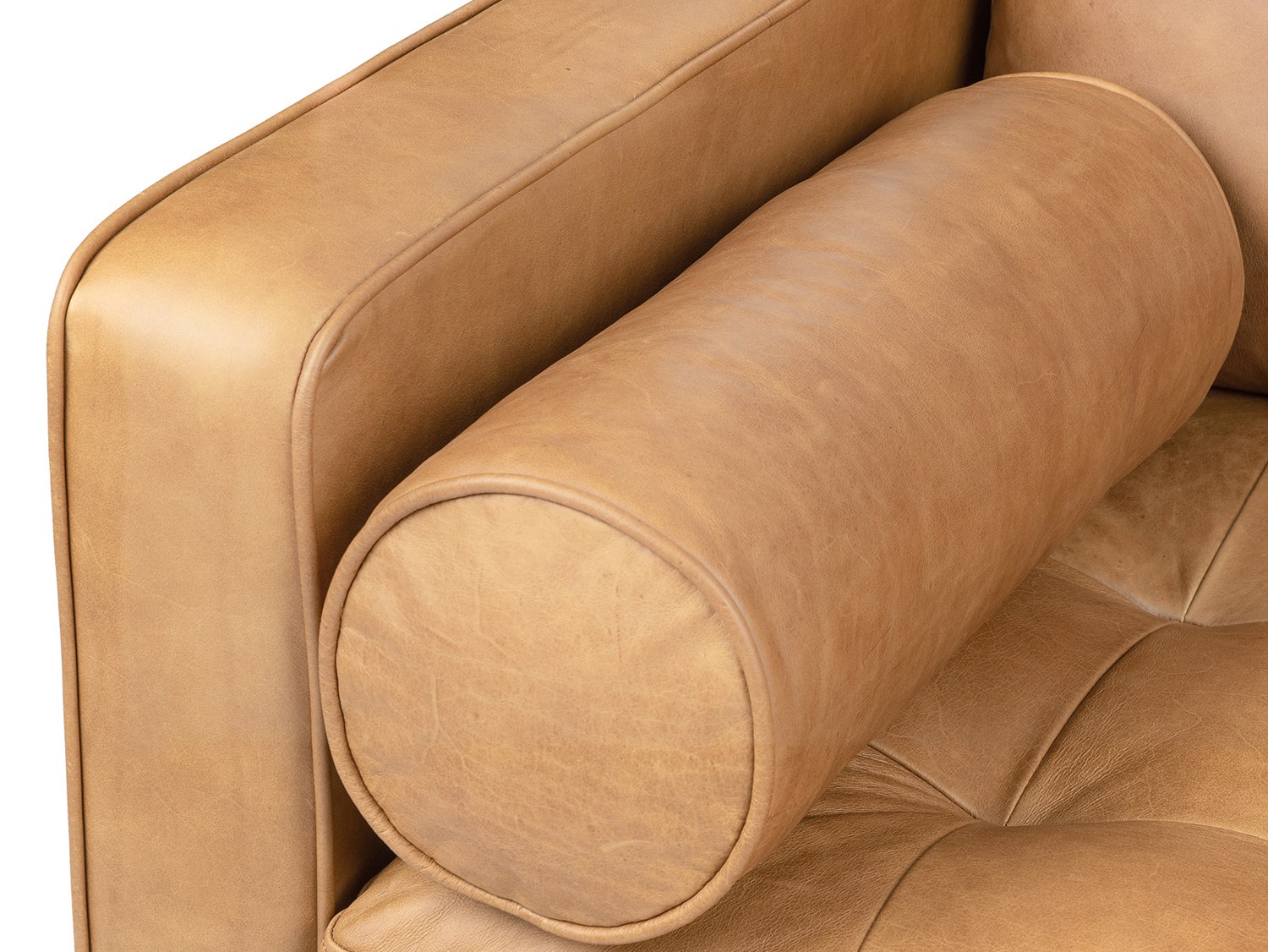 Hình ảnh cận cảnh gối tròn lịch lãm và bề mặt đệm ghế sofa Charme 001. Lớp da full-aniline màu nâu vàng mềm mại, với những…