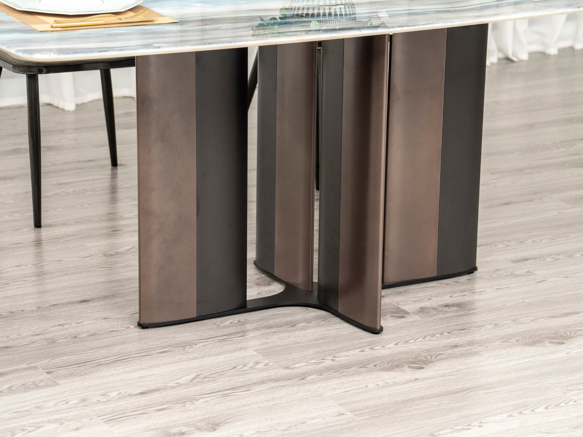 Cận cảnh chân bàn ăn BA934 được làm từ thép không gỉ, thiết kế hình cánh hoa độc đáo với các tấm thép màu nâu sẫm uốn cong…