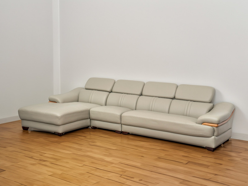 Sofa góc chữ L SF672-Nano1-28 màu be/ghi sáng đặt trong không gian phòng khách mẫu với sàn gỗ màu nâu nhạt và tường trắng…
