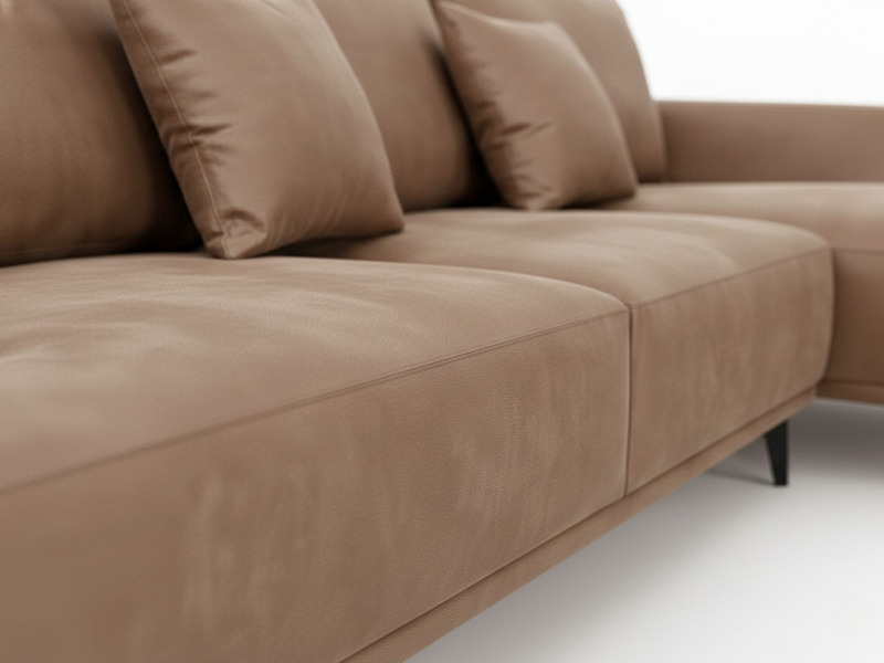 Cận cảnh bề mặt da nhân tạo cao cấp màu nâu be của sofa, thể hiện rõ chất liệu mềm mại và đường may thẳng tắp, chắc chắn…